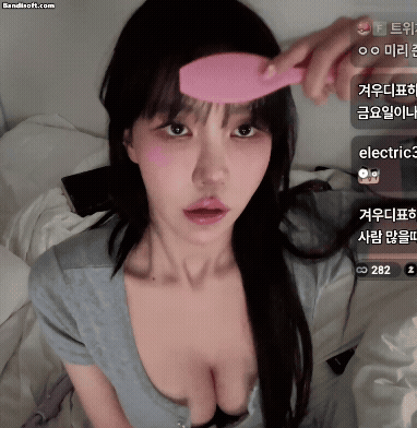 가슴골 오픈된 회색 티셔츠 입고 머리 빗고 있는 겨우디
